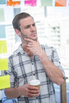 Thoughtful hipster man with coffee