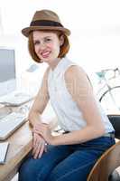smiling hipster businesswoman sitting at her desk