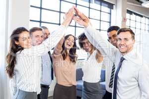 Businesspeople stacking hands in office