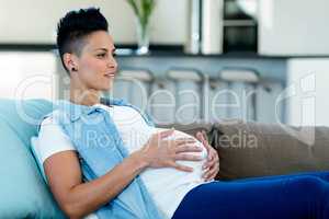 Pregnant woman relaxing on sofa in living room