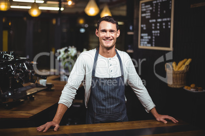 Smiling barista standing in the bar