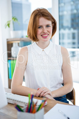smiling hipster business woman with her hands on the desk