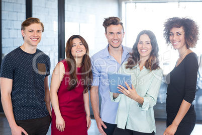 Portrait of colleagues holding digital tablet and smiling