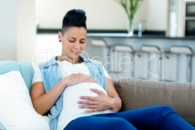 Pregnant woman relaxing on sofa in living room