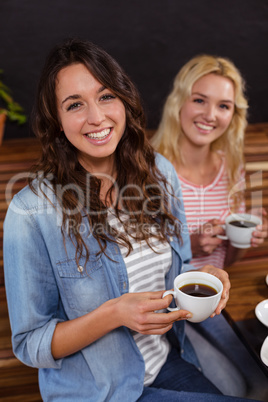 Smiling friends enjoying coffee together