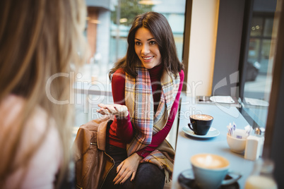 Pretty friends chatting over coffee