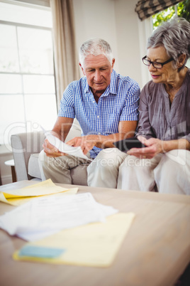 Senior man showing documents to woman