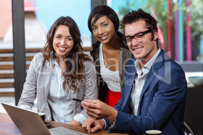 Smiling people using laptop together