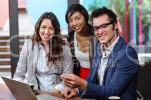 Smiling people using laptop together