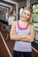 Smiling athletic woman posing with arms crossed