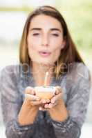 Beautiful woman holding birthday cupcake