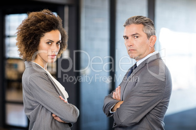 Businessman and businesswoman with arms crossed