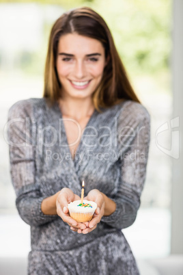 Beautiful woman holding birthday cupcake