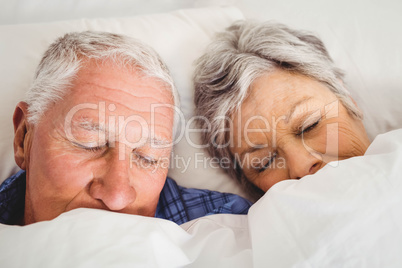 Senior couple sleeping on bed