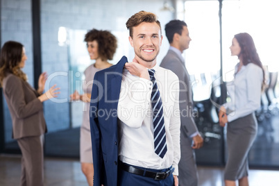 Confident businessman looking at camera while her colleagues dis