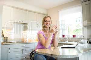 Pretty blonde woman having coffee and using laptop