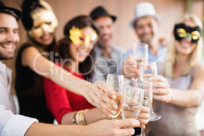 Friends with masks on holding champagne glasses