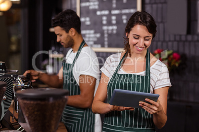 Smiling barista using tablet