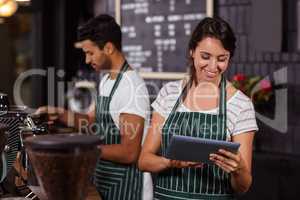 Smiling barista using tablet