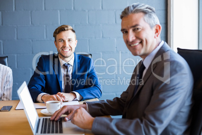 Businessman working on laptop in a meeting