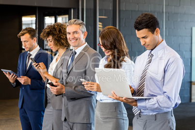 Businesspeople using mobile phone, lap top and digital tablet