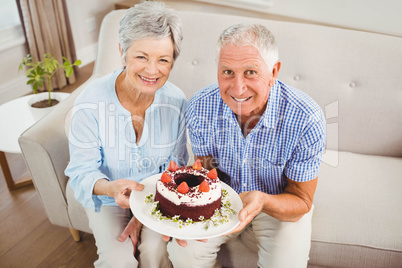 Senior couple holding a cake