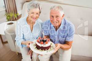 Senior couple holding a cake