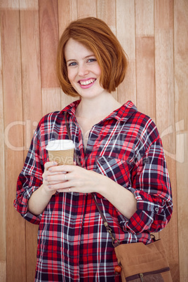 smiling hipster woman holding a take away coffee cup