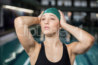Pretty woman adjusting her bathing cap