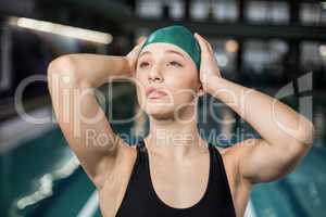 Pretty woman adjusting her bathing cap