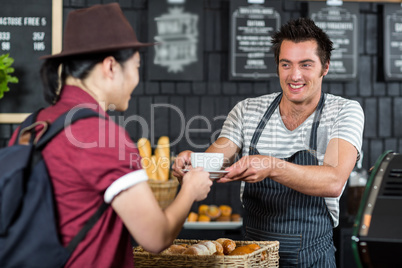 Waiter serving a coffee to a customer