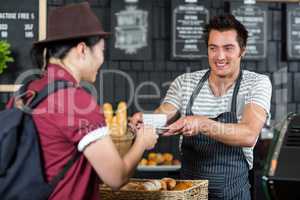 Waiter serving a coffee to a customer