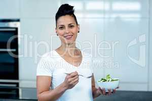 Portrait of pregnant woman holding a bowl of salad