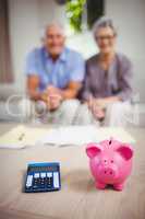 Piggy bank and calculator on table