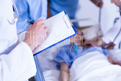 Doctor writing on clipboard