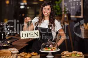 Pretty waitress holding a open sign
