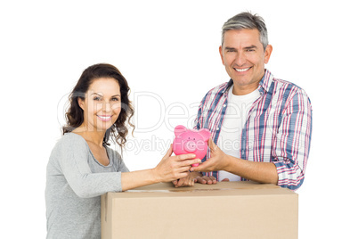 Couple with boxes and piggy bank