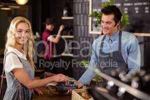 Portrait of a smiling woman paying with credit card