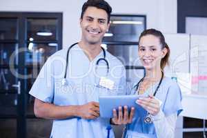 Portrait of doctors using digital tablet and smiling