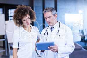 Doctor and colleague looking in digital tablet