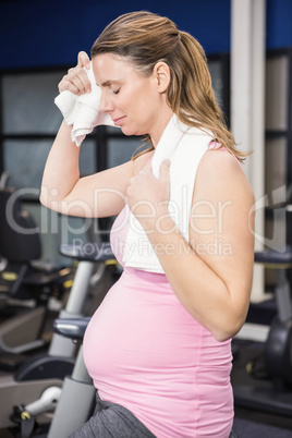 Tired pregnant woman on exercise bike