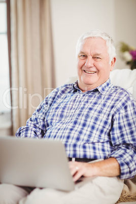 Senior man using laptop in living room