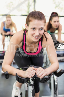 Fit group of people using exercise bike together