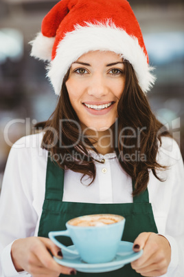 Woman with santa hat holding coffee