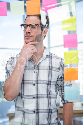 Thoughtful hipster man with post-it