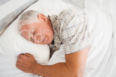 Senior man sleeping on bed