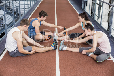 Four athletic women and men stretching