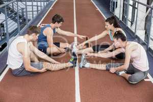 Four athletic women and men stretching