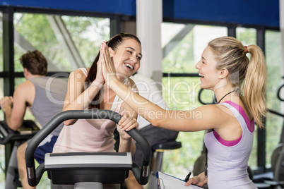 Trainer woman and sportswoman high-fiving