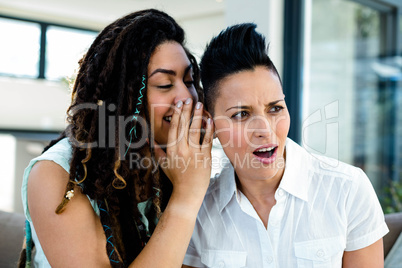 Lesbian couple whispering in ear
